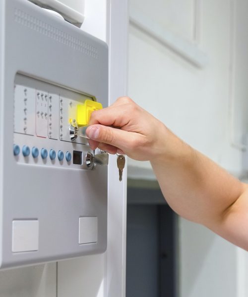 close-up-of-service-technician-opening-fire-panel-in-server-room.jpg
